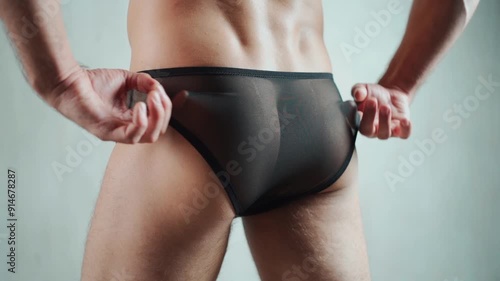 young handsome man in sexy transparent black panties with mesh sheer textile, strong muscular buttocks, hot male in boxer panty lingerie closeup, gay and queer lgbt accessory photo