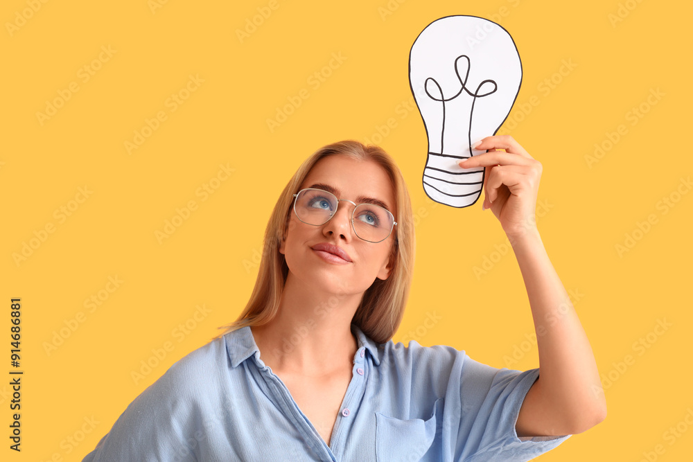 Young businesswoman with drawn light bulb on yellow background. Business idea concept Young businesswoman with drawn light bulb on yellow background. Business idea concept