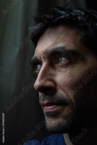 rostro sonriente con mirada lateral sobre fondo oscuro 