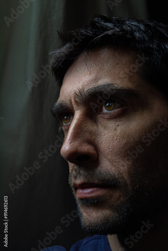 rostro pensativo, poco iluminado en fondo oscuro 