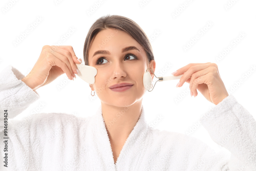 Beautiful young woman with facial massage tools on white background Beautiful young woman with facial massage tools on white background