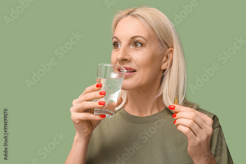 Mature woman taking fish oi...