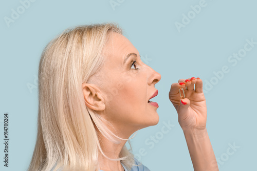 Mature woman taking fish oi...
