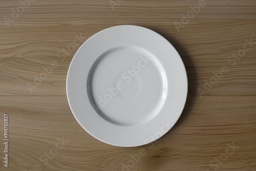 Round white plate on table, top view 