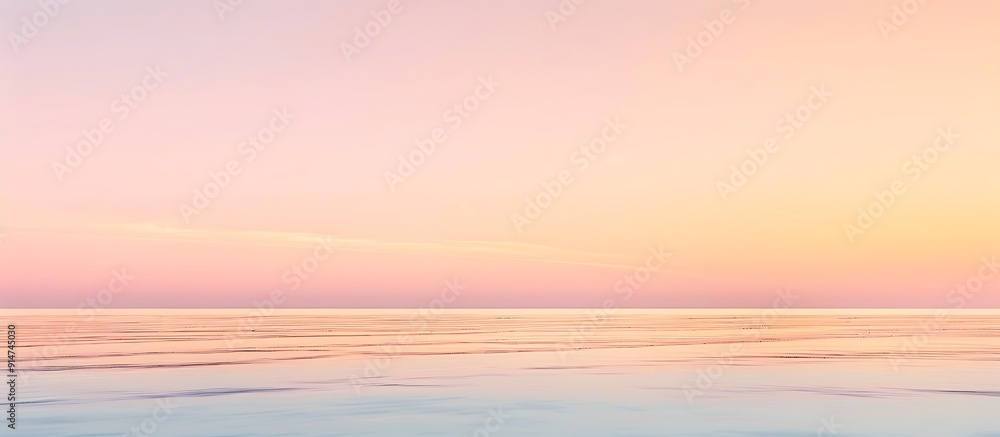Fototapeta premium Soft gradients of pastel pinks and oranges create a serene sunrise horizon.