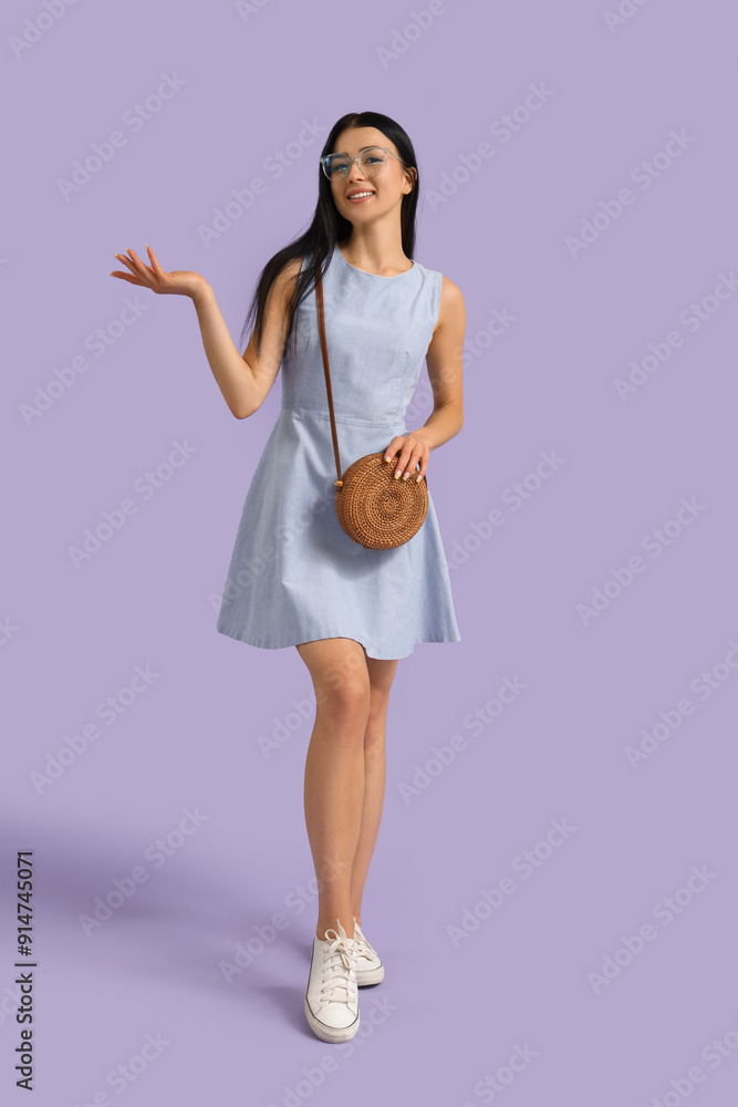 Young woman in eyeglasses with bag on lilac background Young woman in eyeglasses with bag on lilac background