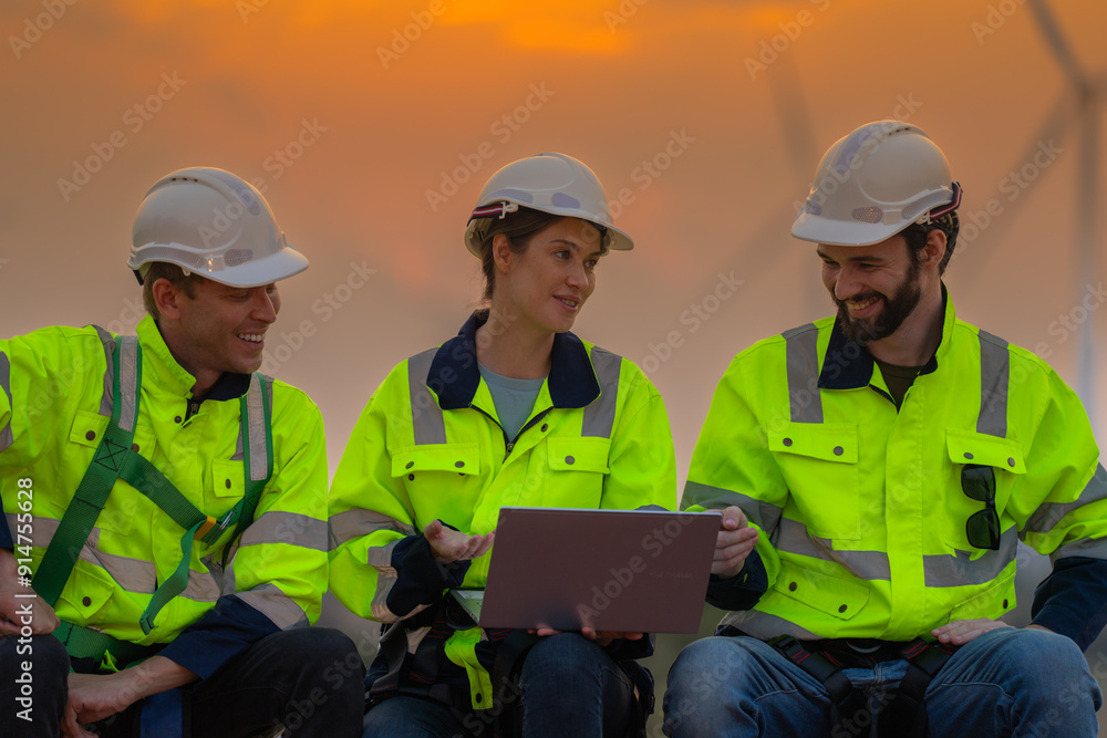 Team Engineers men and woman checking and inspecting on construction with sunset sky. people operation. Wind turbine for electrical of clean energy and environment. Industrial of sustainable. Team Engineers men and woman checking and inspecting on construction with sunset sky. people operation. Wind turbine for electrical of clean energy and environment. Industrial of sustainable.