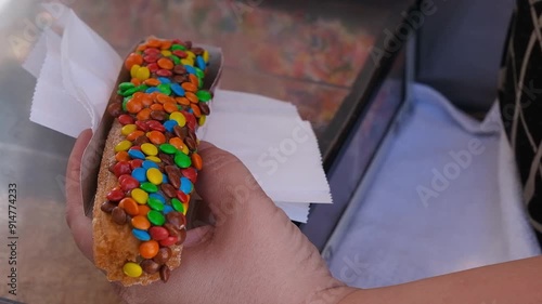 Woman holding a churros with chocolate cream and covered in confetti_6.