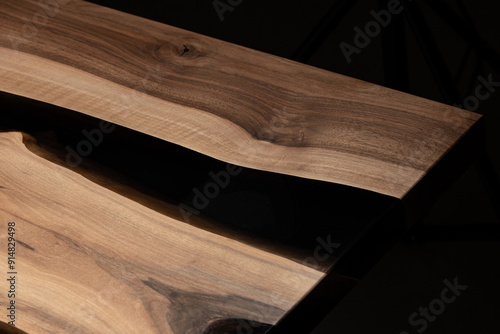 Expensive vintage furniture. The table is covered with epoxy resin and varnished. Luxury quality wood processing. Wooden table on a dark background. Black river made of epoxy resin.