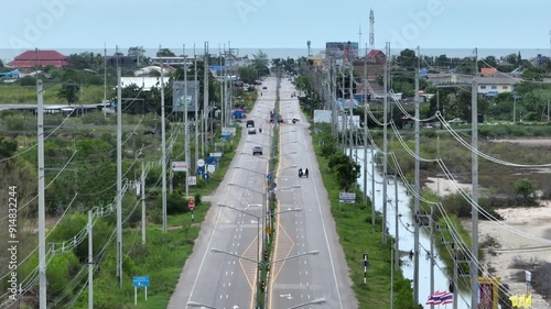 high voltage power line on rural countryside road with vehicle transporting in cloudy sky weather feel like lonely and adventure