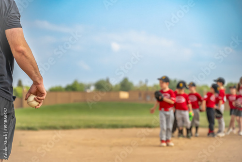Photography Selective focus on a coach getting ready to toss a ball to a child during practi