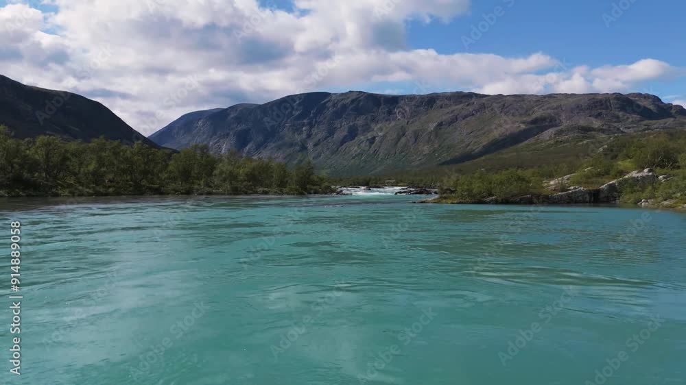 Aerial low flying over turquoise river flowing between lush green mountains. Captures the beauty of nature and serene landscapes. Aerial low flying over turquoise river flowing between lush green mountains. Captures the beauty of nature and serene landscapes.