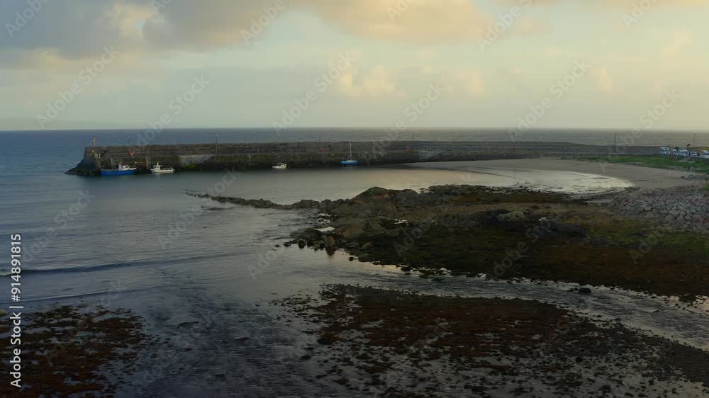 Establishing aerial pan shot of Spiddal Beach and Pier at sunset, capturing rhythmic movements and stunning light. Ireland Establishing aerial pan shot of Spiddal Beach and Pier at sunset, capturing rhythmic movements and stunning light. Ireland
