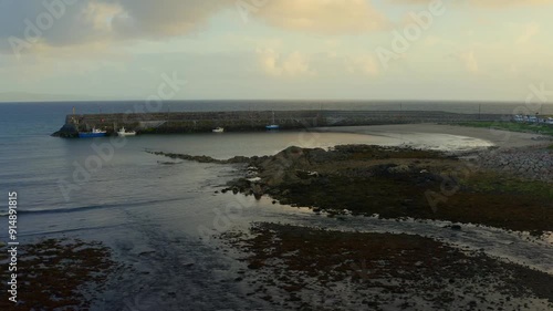 Establishing aerial pan shot of Spiddal Beach and Pier at sunset, capturing rhythmic movements and stunning light. Ireland photo