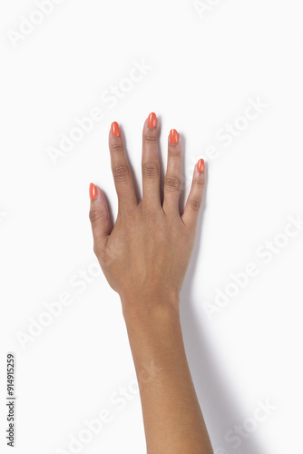 White woman manicured hand with spritz nail polish Makeup isolated on white background. Makeup and Nail art manicure concept. Top view. Female hand model. - photo