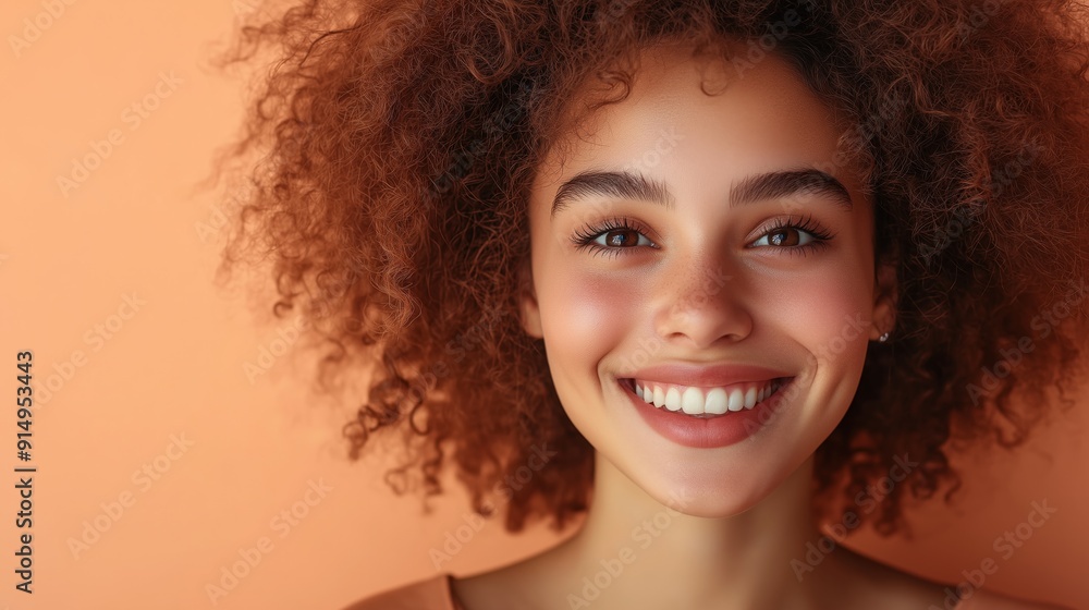Girl smiles and waves cheerfully with a vibrant orange backdrop Girl smiles and waves cheerfully with a vibrant orange backdrop