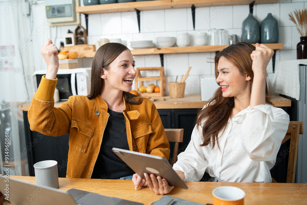 Two women read books, use laptops to work, kitchen Two women read books, use laptops to work, kitchen