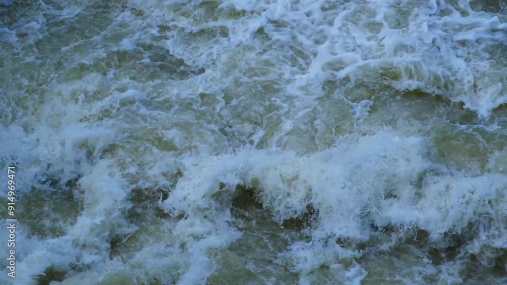 A powerful stream of water rages, creating foam and splashes. The water flows off the dam, exploding into violent splashes and whirlpools. A powerful stream of water rages, creating foam and splashes. The water flows off the dam, exploding into violent splashes and whirlpools.