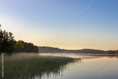 A calm lake with a beautiful blue sky in the background