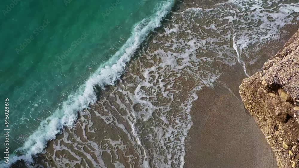 Beautiful sea beach, Turquoise sea water rolls in waves of surf on the shore on a sunny summer day. View from above on a deserted beach and calm sea surf. 4K video on a marine theme. Beautiful sea beach, Turquoise sea water rolls in waves of surf on the shore on a sunny summer day. View from above on a deserted beach and calm sea surf. 4K video on a marine theme.