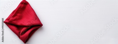  A red napkin rests atop a white table, near a pair of scissors