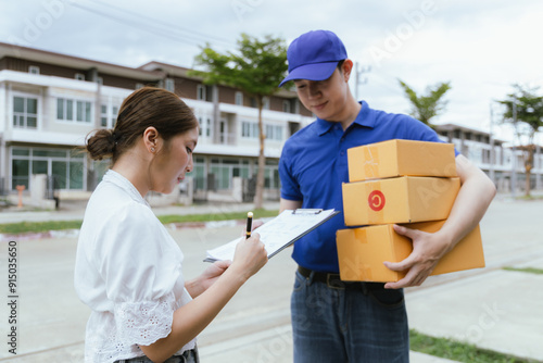 Quadro su tela A cheerful Asian woman receives a package from a delivery man in uniform at her doorstep