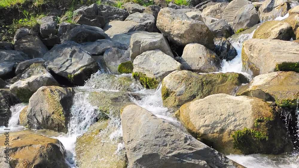 Crystal clear water flowing over a waterfall with many moss-covered rocks. Crystal clear water flowing over a waterfall with many moss-covered rocks.