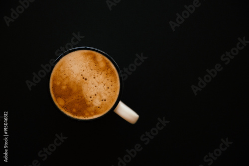 cup of coffee with foam on black background