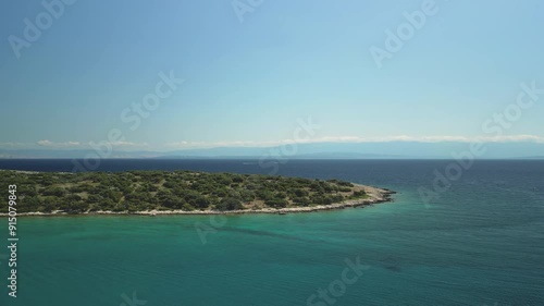 Scenic aerial view of Meli Bay's clear turquoise waters and lush green coastline on a sunny day photo