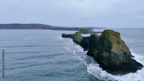 Waves crashing along the rocky spine of Worms head, Rhossili Bay, Wales at high tide photo