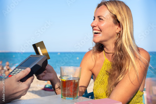 Young woman holding a credit card and making a payment transaction. photo