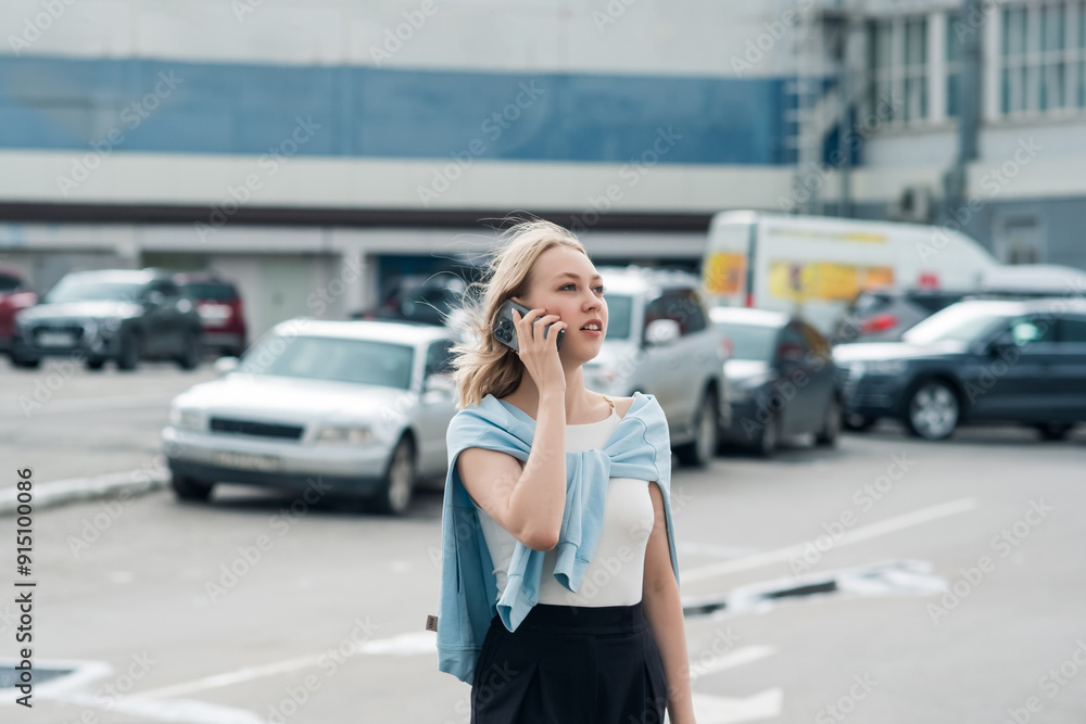 Young beautiful blonde turned around while talking on the phone in the city. Young beautiful blonde turned around while talking on the phone in the city.