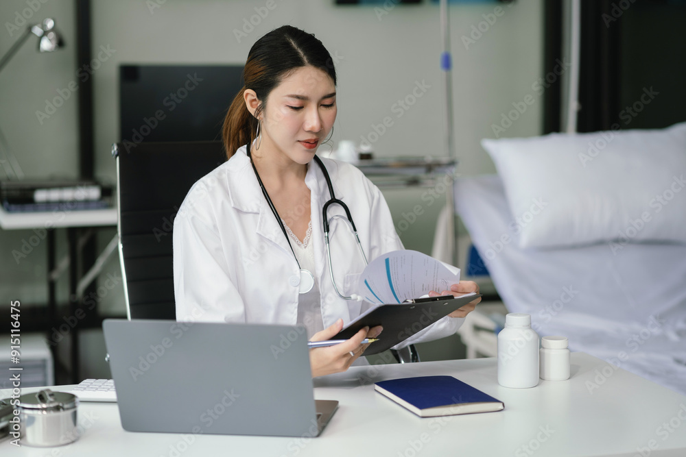 Doctor working on laptop computer and tablet and medical stethoscope on clipboard on desk, electronics medical record system EMRs concept. Doctor working on laptop computer and tablet and medical stethoscope on clipboard on desk, electronics medical record system EMRs concept.