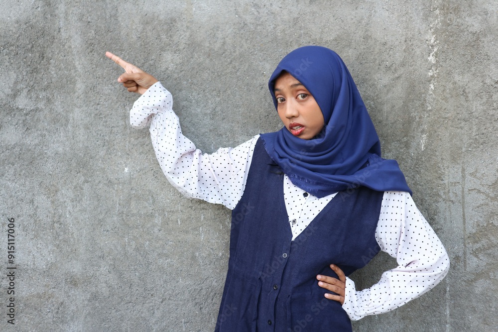 Portrait a cheerful asian muslim woman pointing to a side Portrait a cheerful asian muslim woman pointing to a side