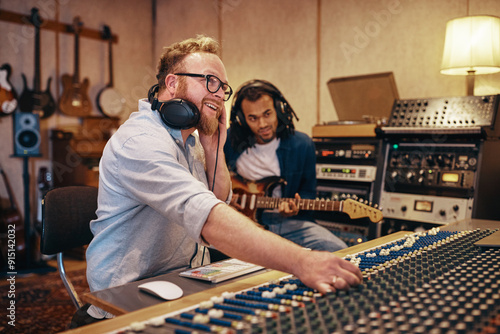 Producer and musican working on songs together in a studio