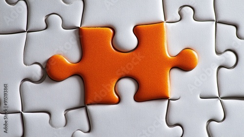 Picture of an orange puzzle piece that fits into a white puzzle. Teamwork, solutions, and problem-solving concepts are emphasized.