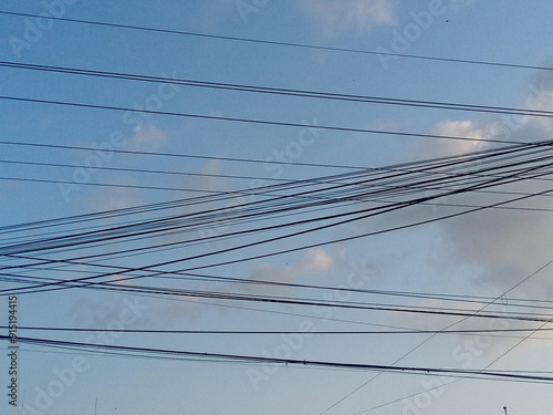 power lines in the sky. electric wires and telephone line against cloudy blue sky in the afternoon. dangerously chaotic power lines in the middle of the city. power line cable photo