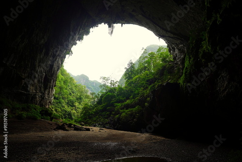 Fototapeta Naklejka Na Ścianę i Meble -  View through rock arch into the jungle at the cave entrance of Hang En Cave at Phong-Nha-ke-Bang National Park, Vietnam