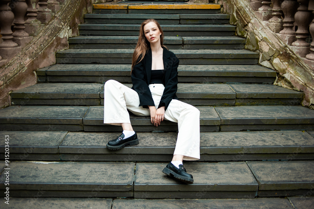Young woman with long hair black jacket and white trousers street style Young woman with long hair black jacket and white trousers street style