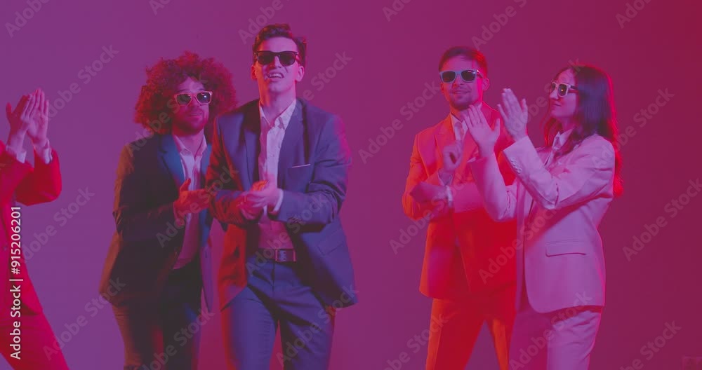Happy group of young people, dancers in colorful business suits, is dancing in neon light at dance party. Disco music sets mood for vibrant and energetic dance performance. Happy group of young people, dancers in colorful business suits, is dancing in neon light at dance party. Disco music sets mood for vibrant and energetic dance performance.