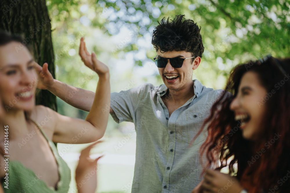 Group of young friends enjoying a sunny day in the park, laughing and having fun together. Group of young friends enjoying a sunny day in the park, laughing and having fun together.