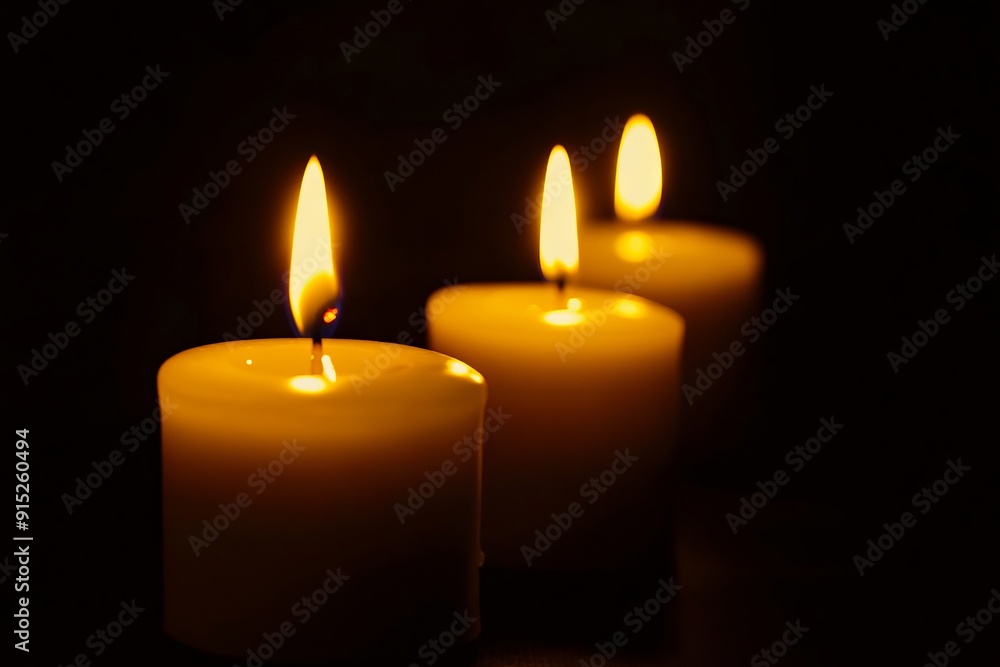 Three white candles are lit in the dark Three white candles are lit in the dark