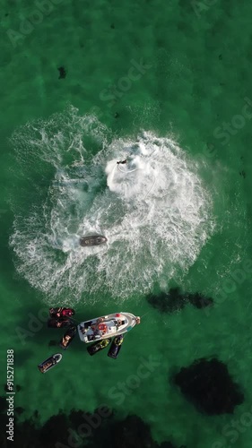 A man flies on a FlyBoard. Aerial top down view. Water extreme sport, azure summer sea with outdoors active people enjoying water sports. Flyboarding and seariding, Recreation and sports concepts. photo