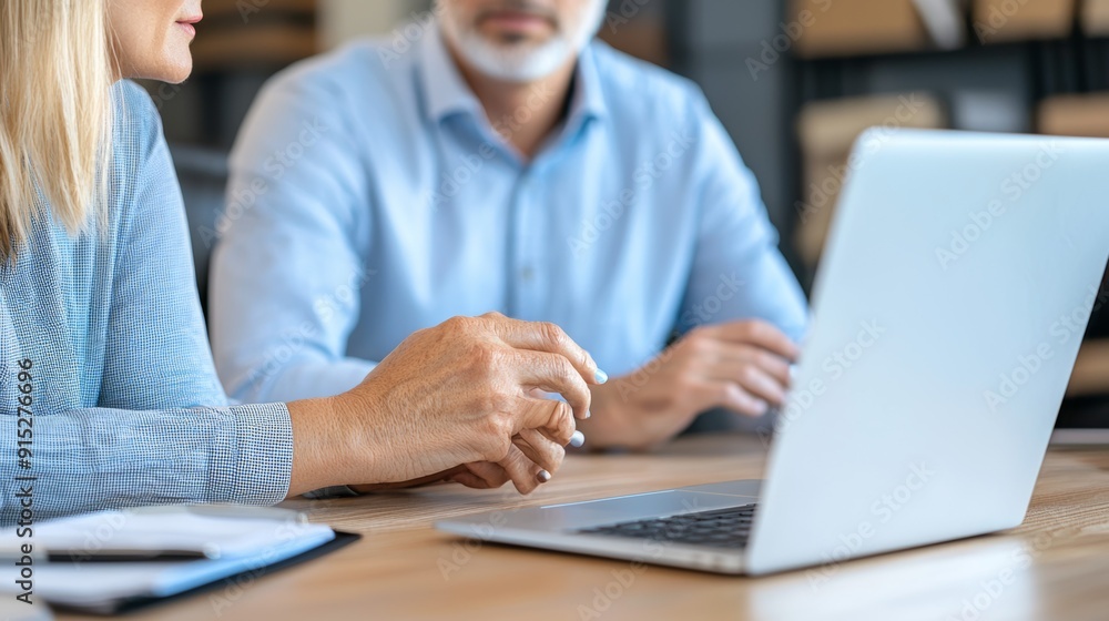 a man and woman sitting at a table with a laptop a man and woman sitting at a table with a laptop