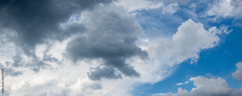 Fototapeta premium Dark storm clouds cover the blue sky with white clouds