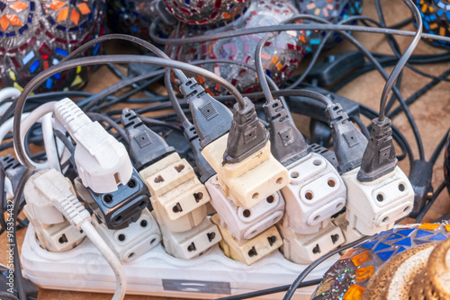 Old and damaged electric adapter power plug has many appliances are plugged outlet socket concept of risk danger overloaded current electrical. Overloaded power plugs, close up