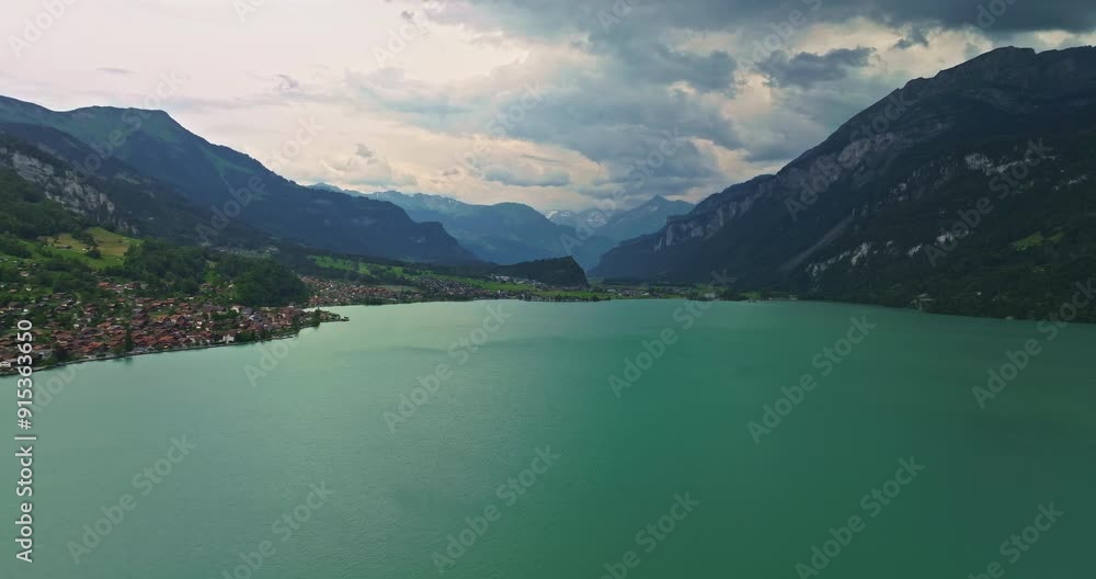 Water transport in Switzerland. Navigating a Swiss Lake. Aerial view steamboat ship on lake Interlaken. Switzerland summer tourism destination. Turquoise blue water. Swiss flag on a passenger ship Water transport in Switzerland. Navigating a Swiss Lake. Aerial view steamboat ship on lake Interlaken. Switzerland summer tourism destination. Turquoise blue water. Swiss flag on a passenger ship