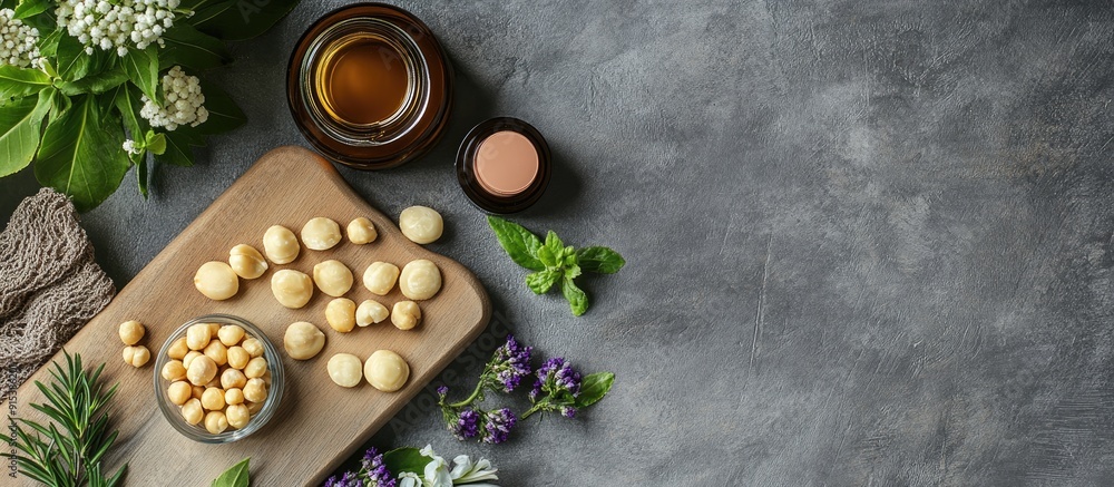 Arrangement featuring a board cosmetics and macadamia nuts on a grey table. with copy space image. Place for adding text or design Arrangement featuring a board cosmetics and macadamia nuts on a grey table. with copy space image. Place for adding text or design