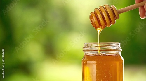 Golden honey drips from a wooden spoon into a glass jar, capturing a warm kitchen atmosphere filled with natural light