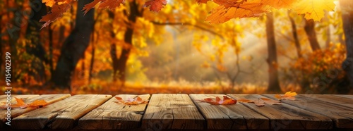 Autumn background featuring orange and yellow leaves on a wooden table with a blurred forest landscape at sunset. This abstract fall banner is perfect for product displays.